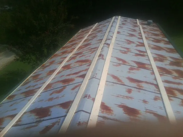 Rusted metal roof panels with new wood purlins before replacement — Storm Damage Roof Repair in Lakeside by Roofing Brothers