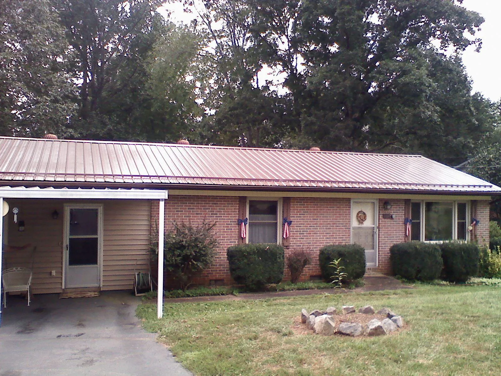 Bronze metal roof and carport on a brick ranch home — Roof Repair work by our crew in Lakeside